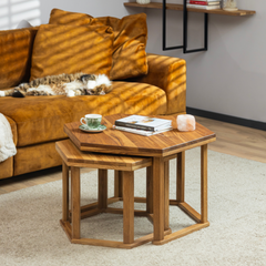 The HEX coffee table styled with books, tea and a candle for a cozy setting. A cat is sleeping in the background on the couch. The coffee tables are stacked.