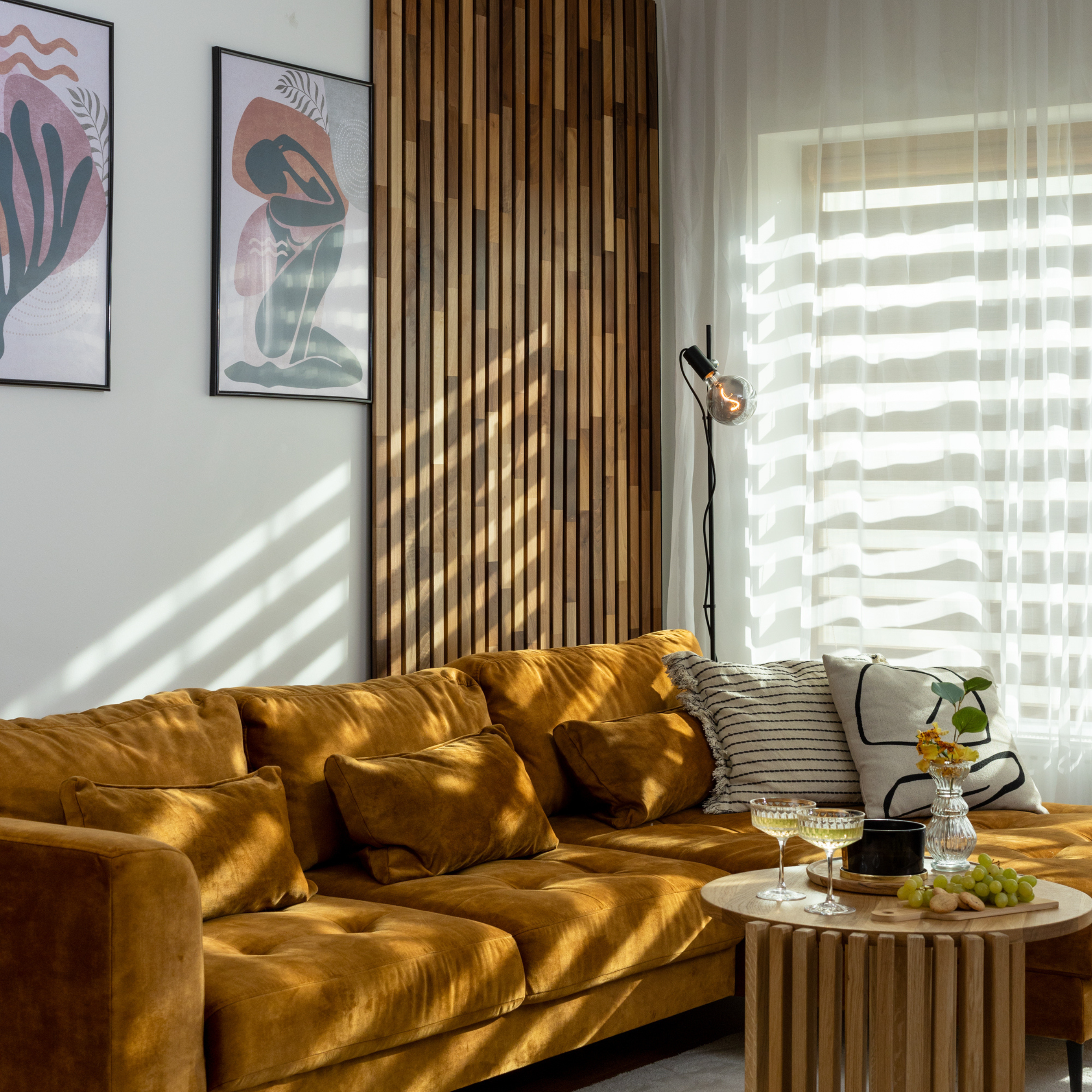 Natural walnut solid wood acoustic panels on a modern and cosy living room wall with a yellow couch and solid wood coffee table