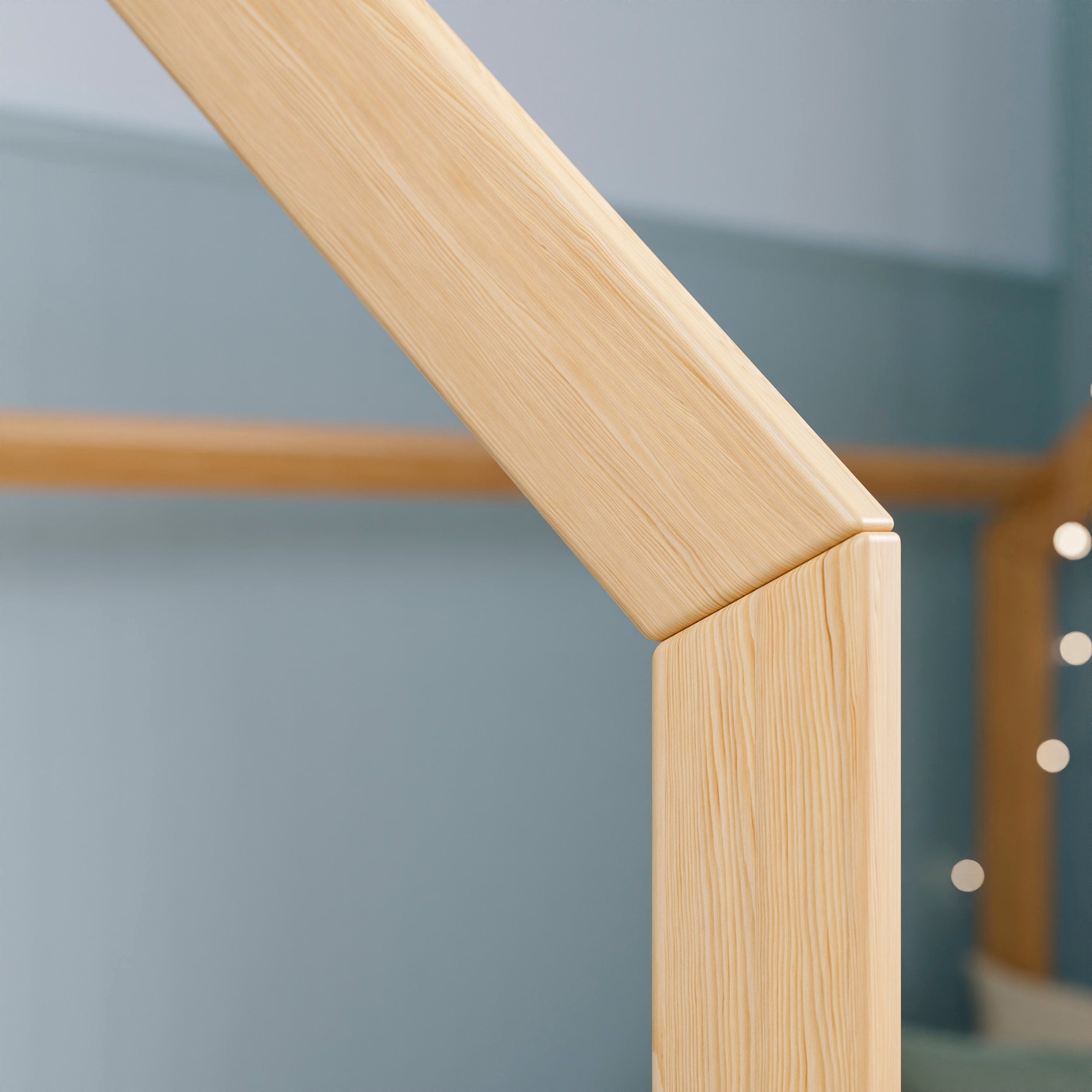 Close up view of the natural Montessori House bed with barriers highlighting the wood grain