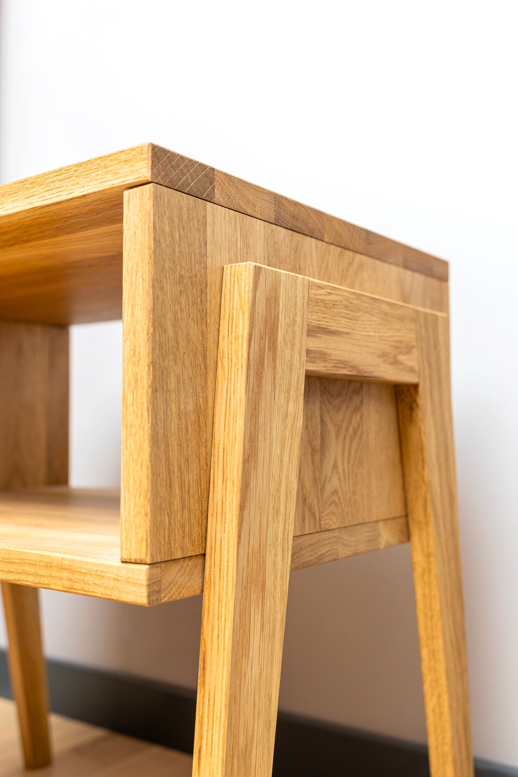 Vue rapprochée de la table de chevet en bois mettant en valeur le grain naturel du bois de chêne.