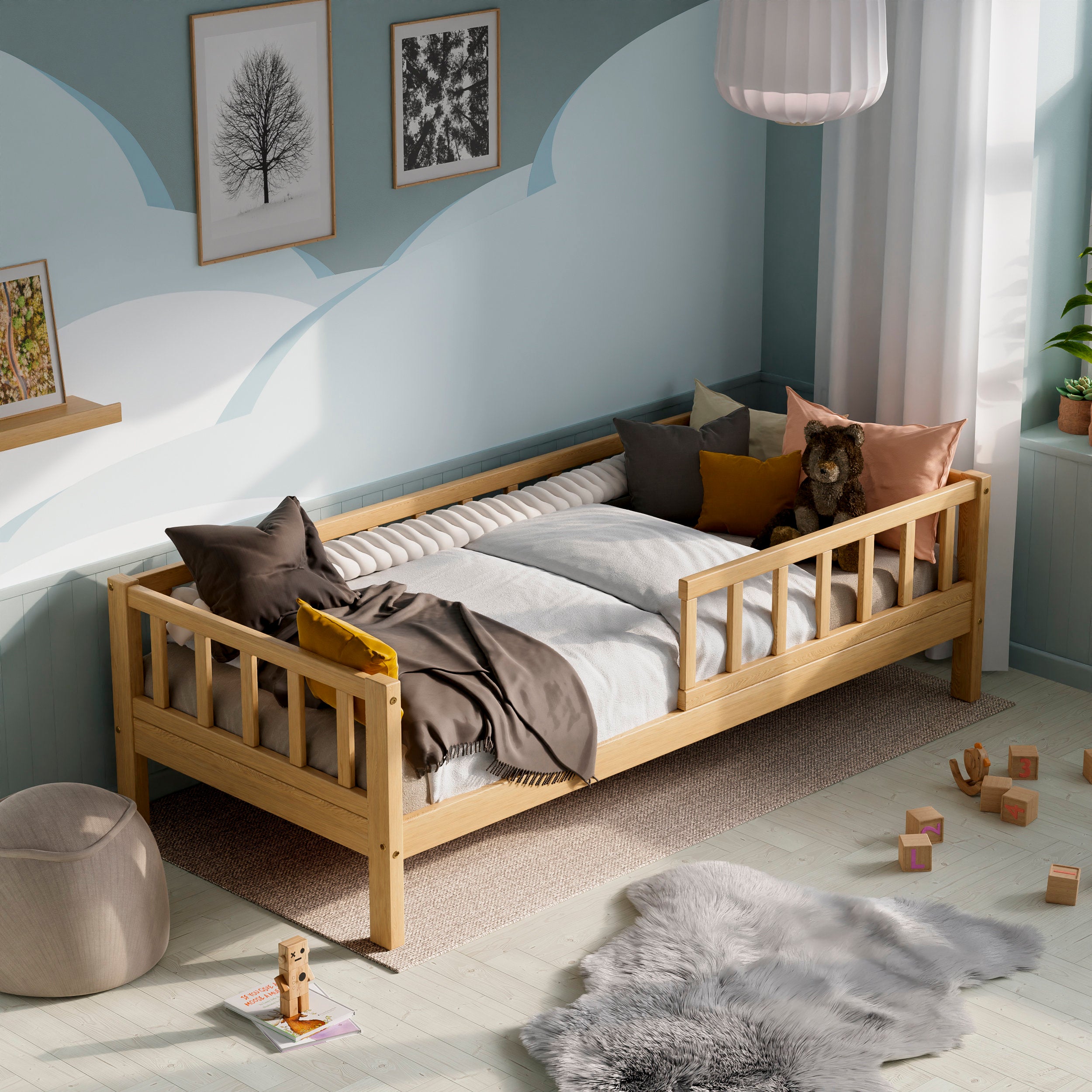 Wooden toddler bed with barriers in a kids room decorated with pillows and toys