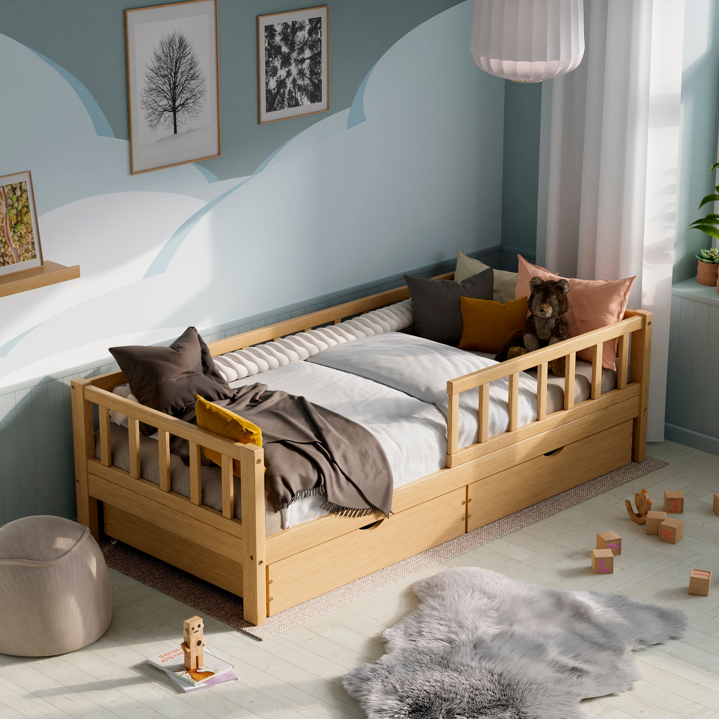 Wooden toddler bed with barriers, drawers and a pull-out bed in a kids room decorated with pillows and toys