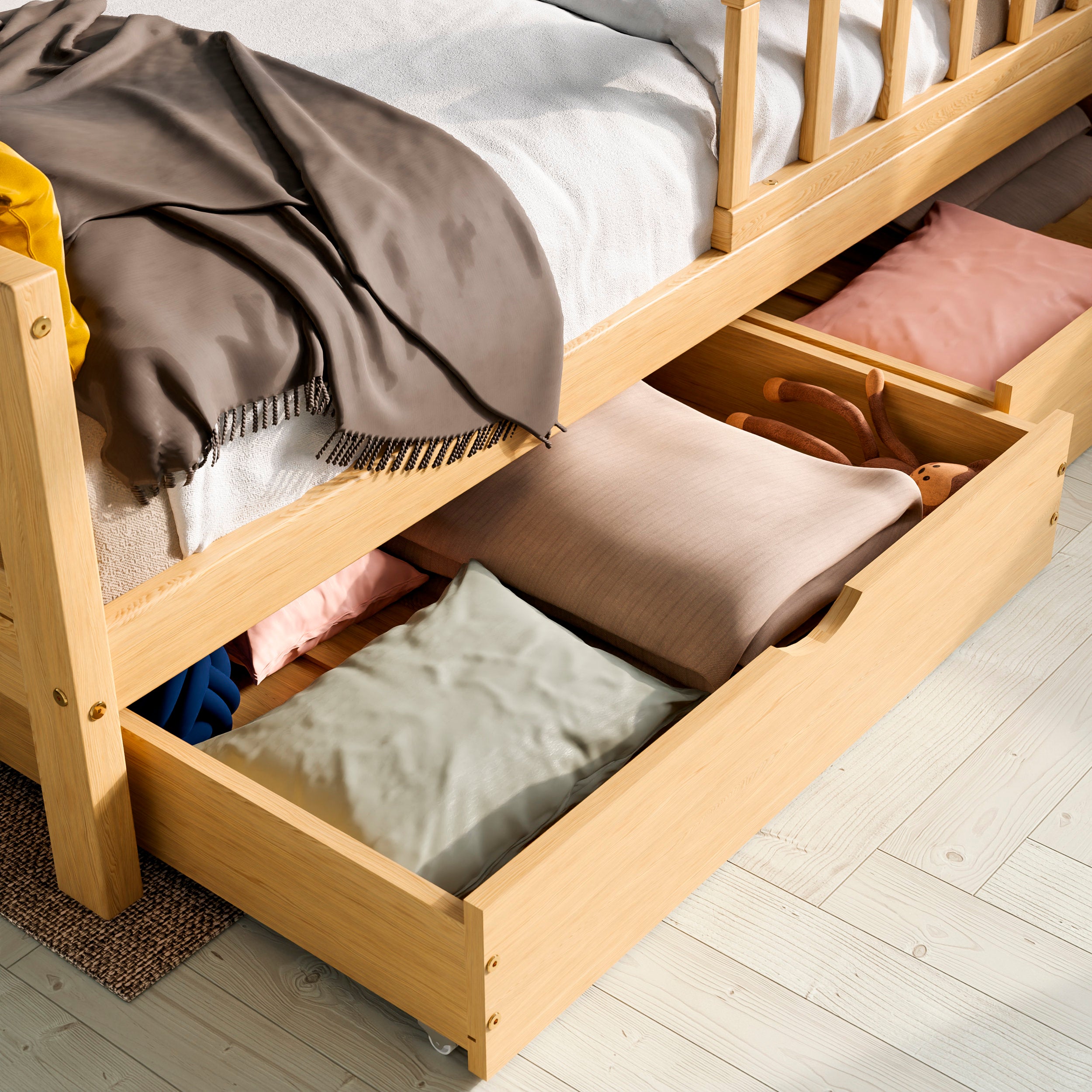 Close up view of the solid wood toddler bed with drawers highlighting the two drawers pulled out