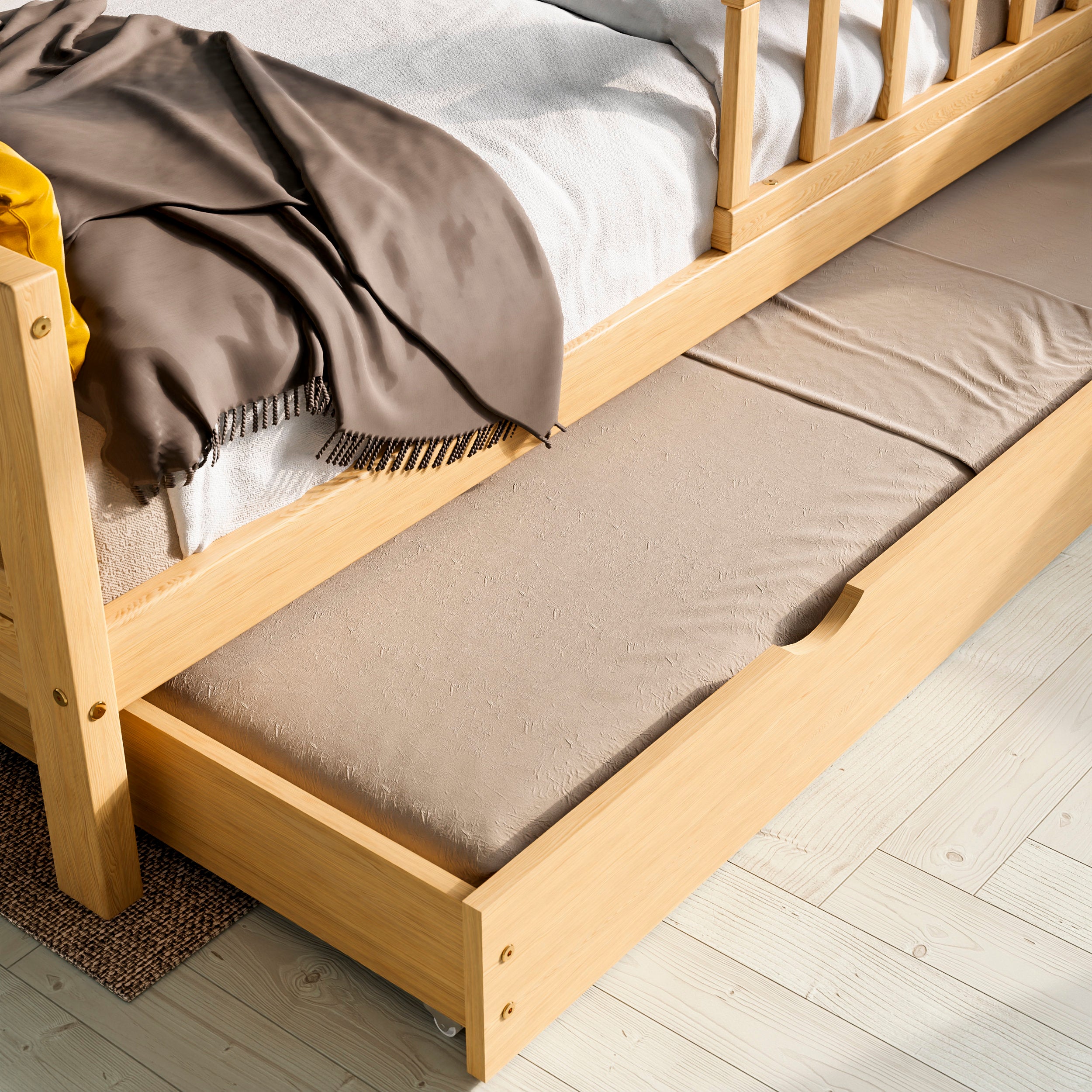 Close up view of the solid wood toddler bed with drawers highlighting the pull out bed