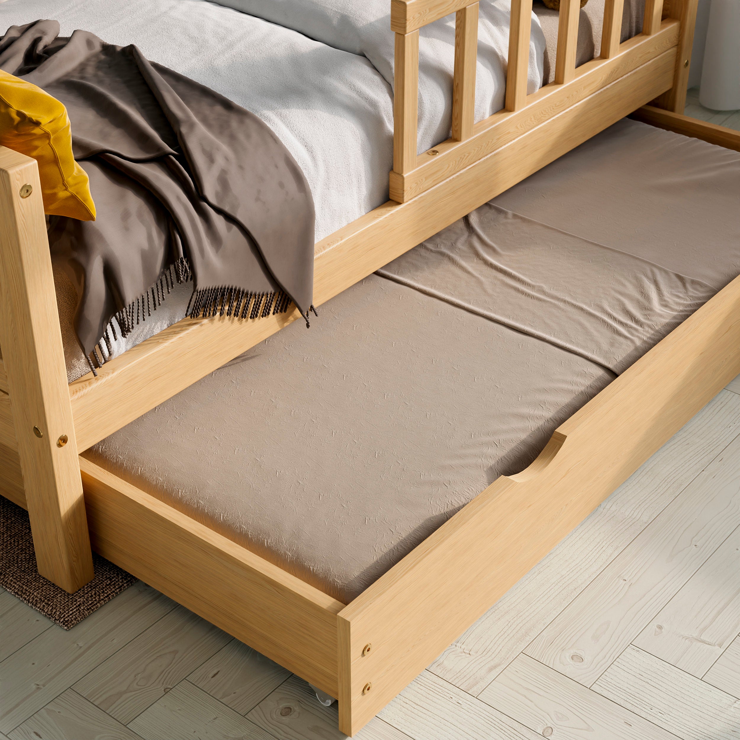 Close up view of the solid wood toddler bed with drawers highlighting the pull-out bed