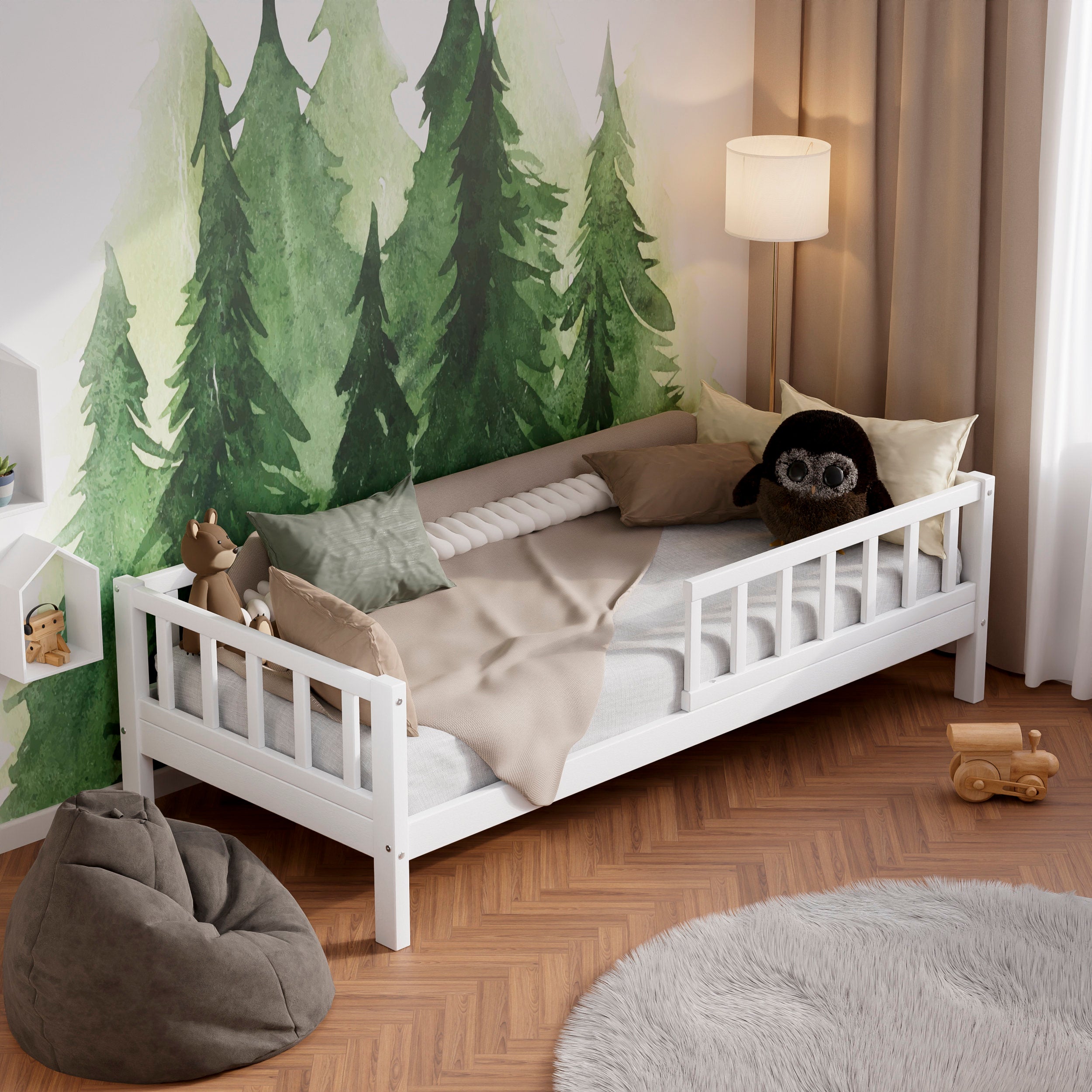 White wooden toddler bed with barriers in a kids room decorated with pillows and toys