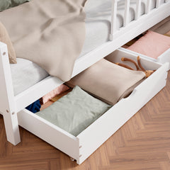 Close up view of the white solid wood toddler bed VARBLANE with drawers highlighting the two drawers pulled out