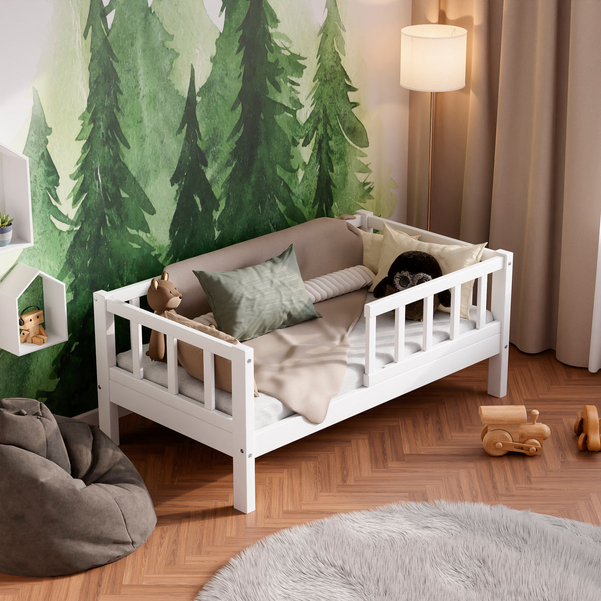 White wooden toddler bed with barriers in a kids room decorated with pillows and toys