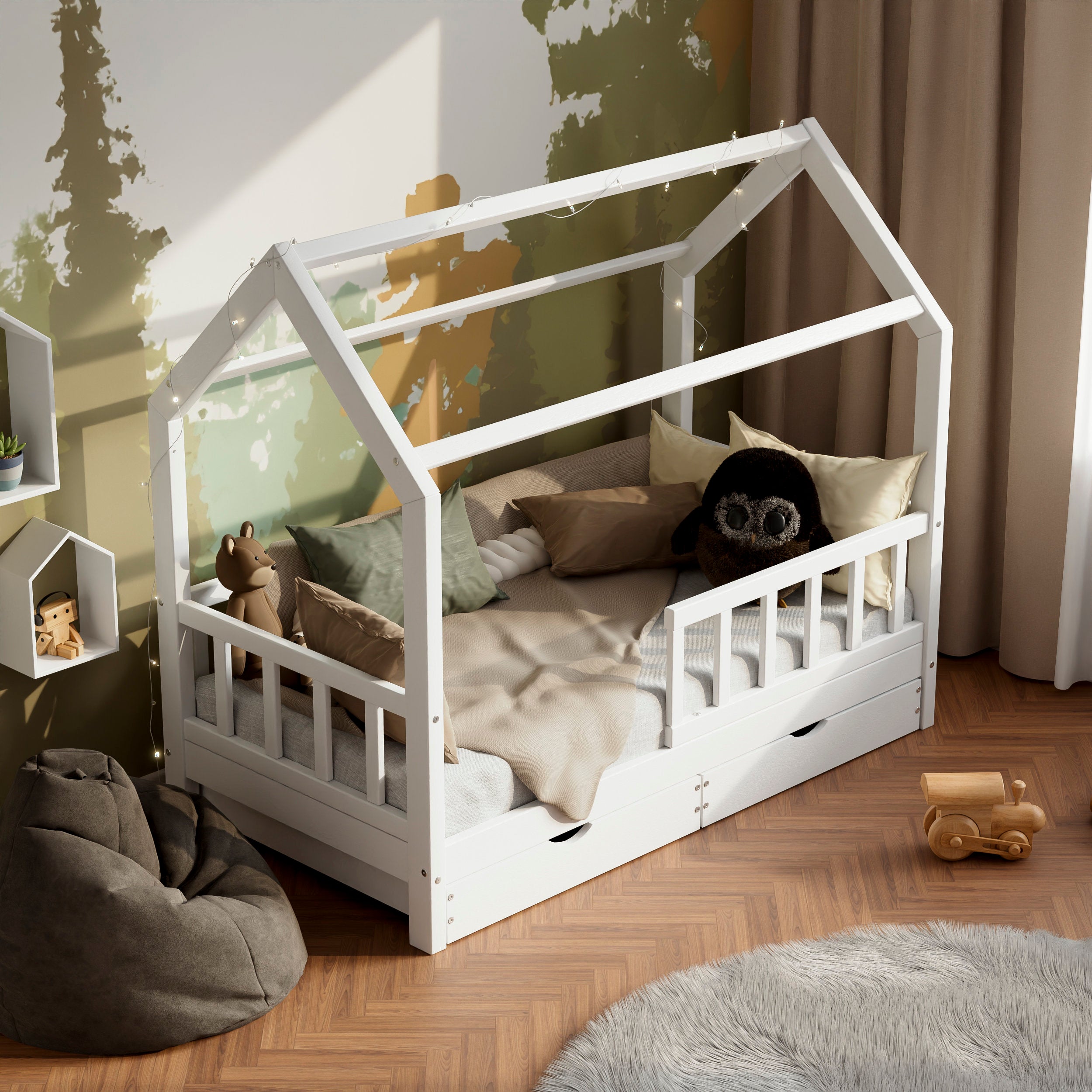 Lit d'enfant en bois blanc ÖÖBIK avec deux tiroirs dans une chambre d'enfant moderne décorée avec des coussins et des jouets.