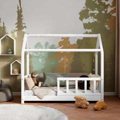 Front view of the white wooden house bed with barriers ÖÖBIK in a modern kids room decorated with pillows and toys