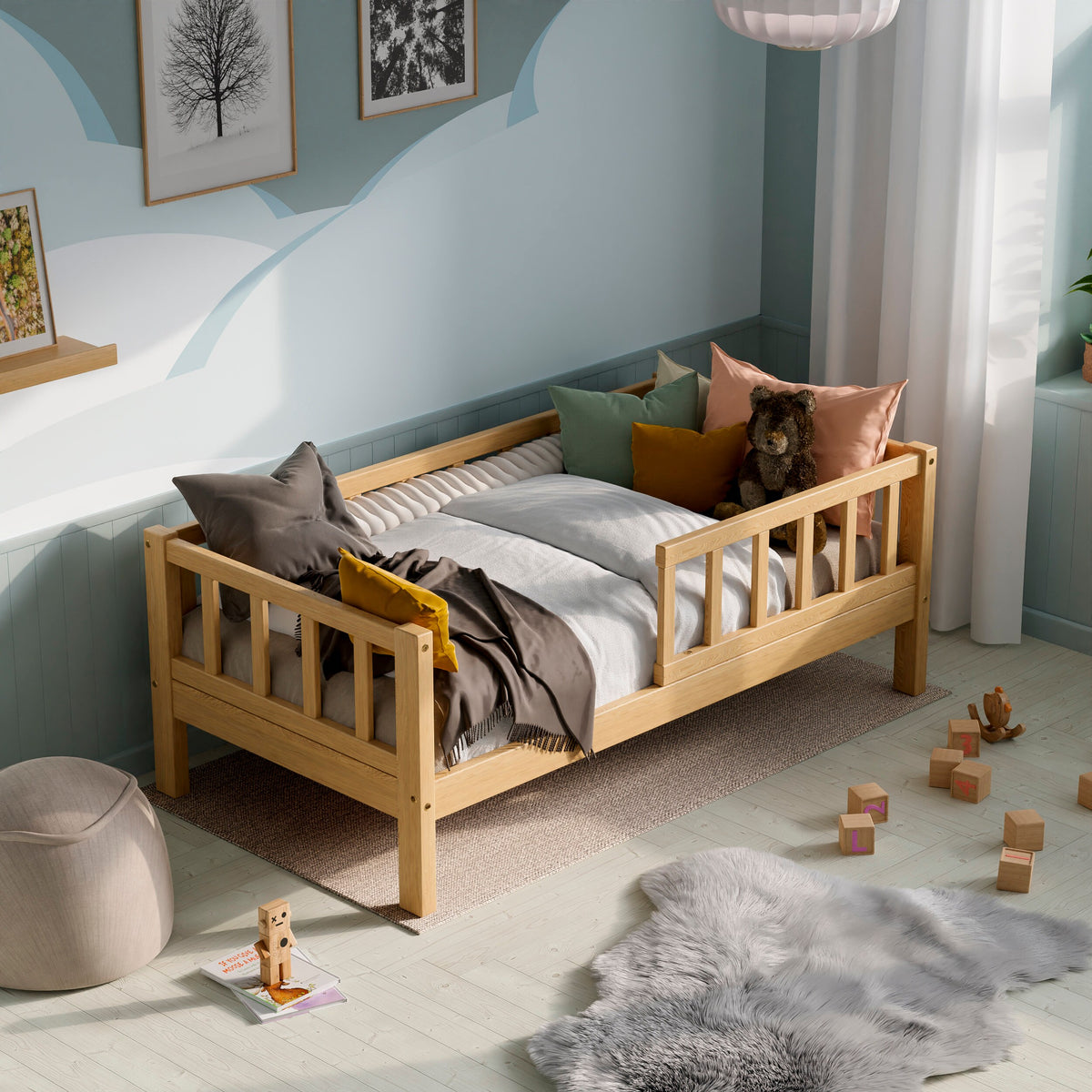 Wooden toddler bed with barriers in a kids room decorated with pillows and toys