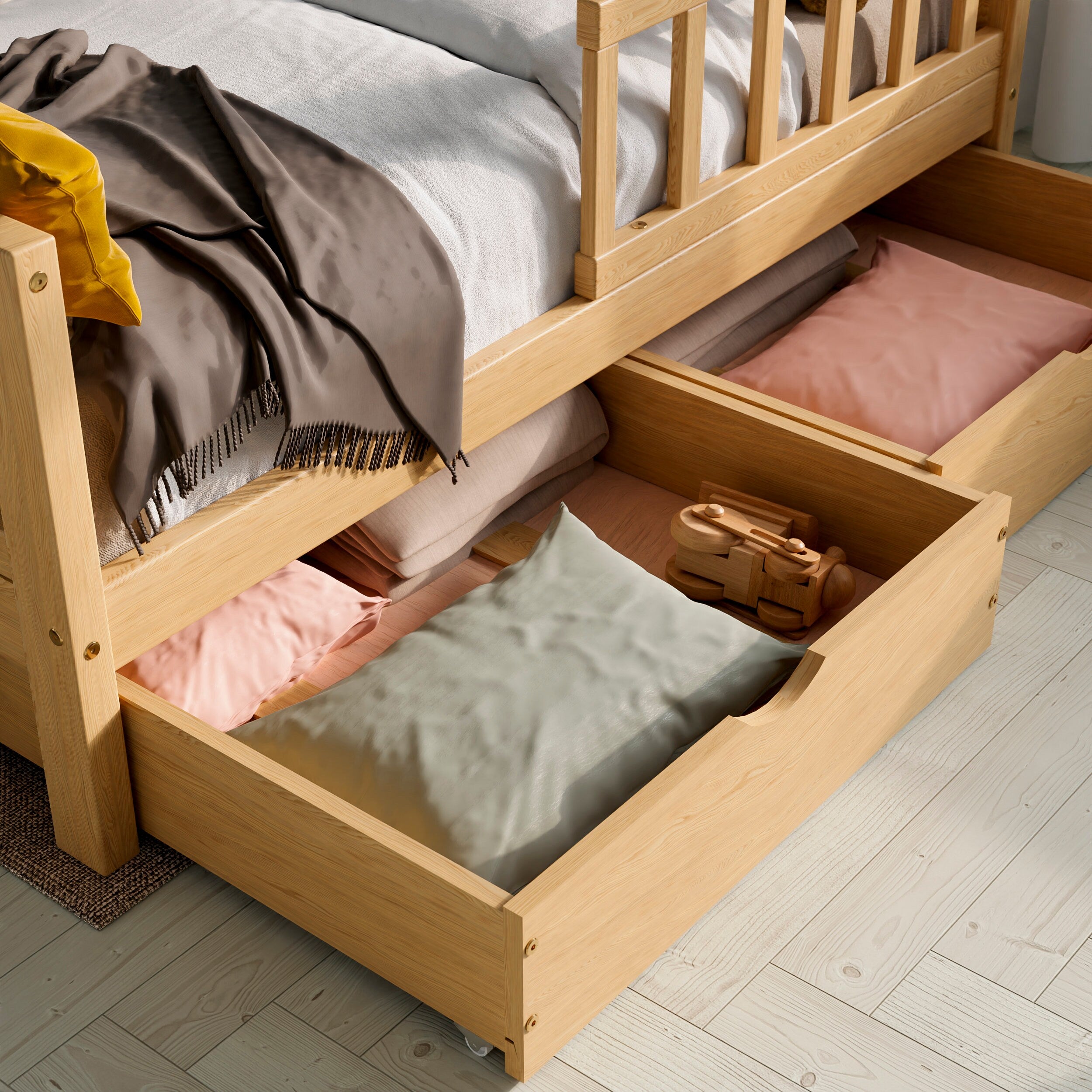 Close up view of the solid wood toddler bed with drawers highlighting the two drawers pulled out