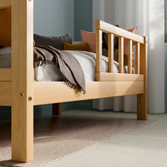 Close up view of Solid wood toddler bed highlighting the barriers and wood grain