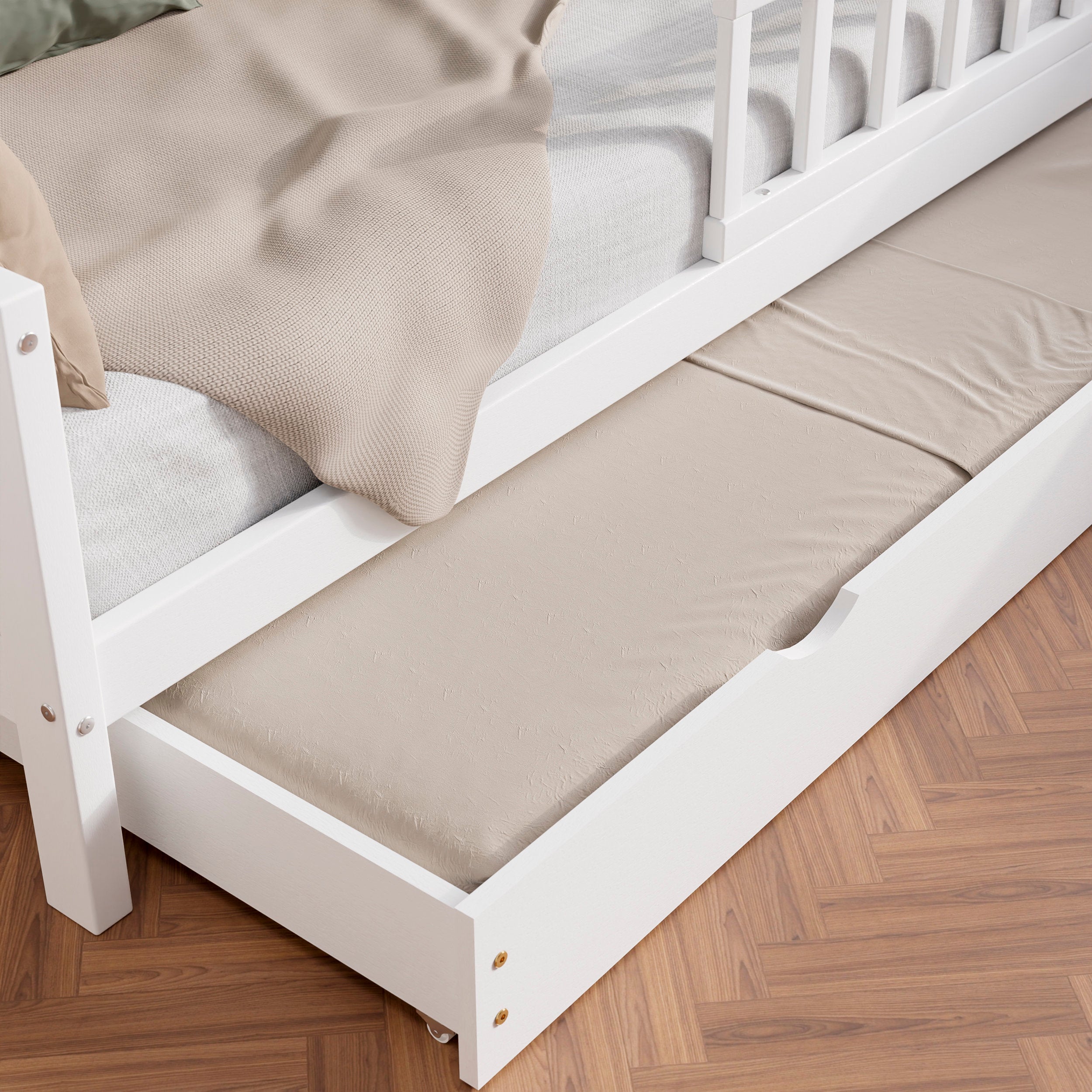 Close up view of the white solid wood toddler bed VARBLANE with drawers highlighting the pull-out bed