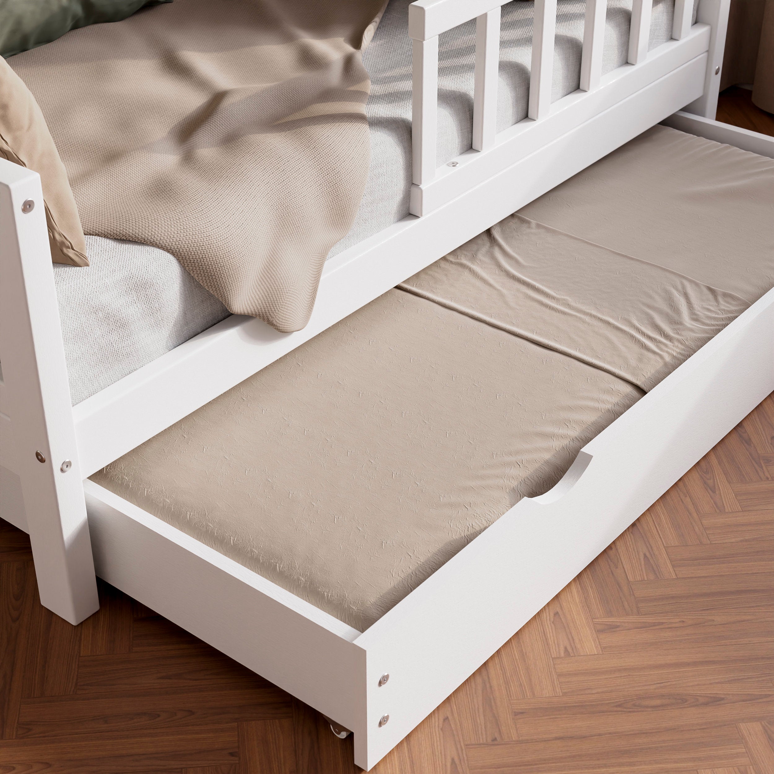 Close up view of the white solid wood toddler bed VARBLANE with drawers highlighting the pull-out bed