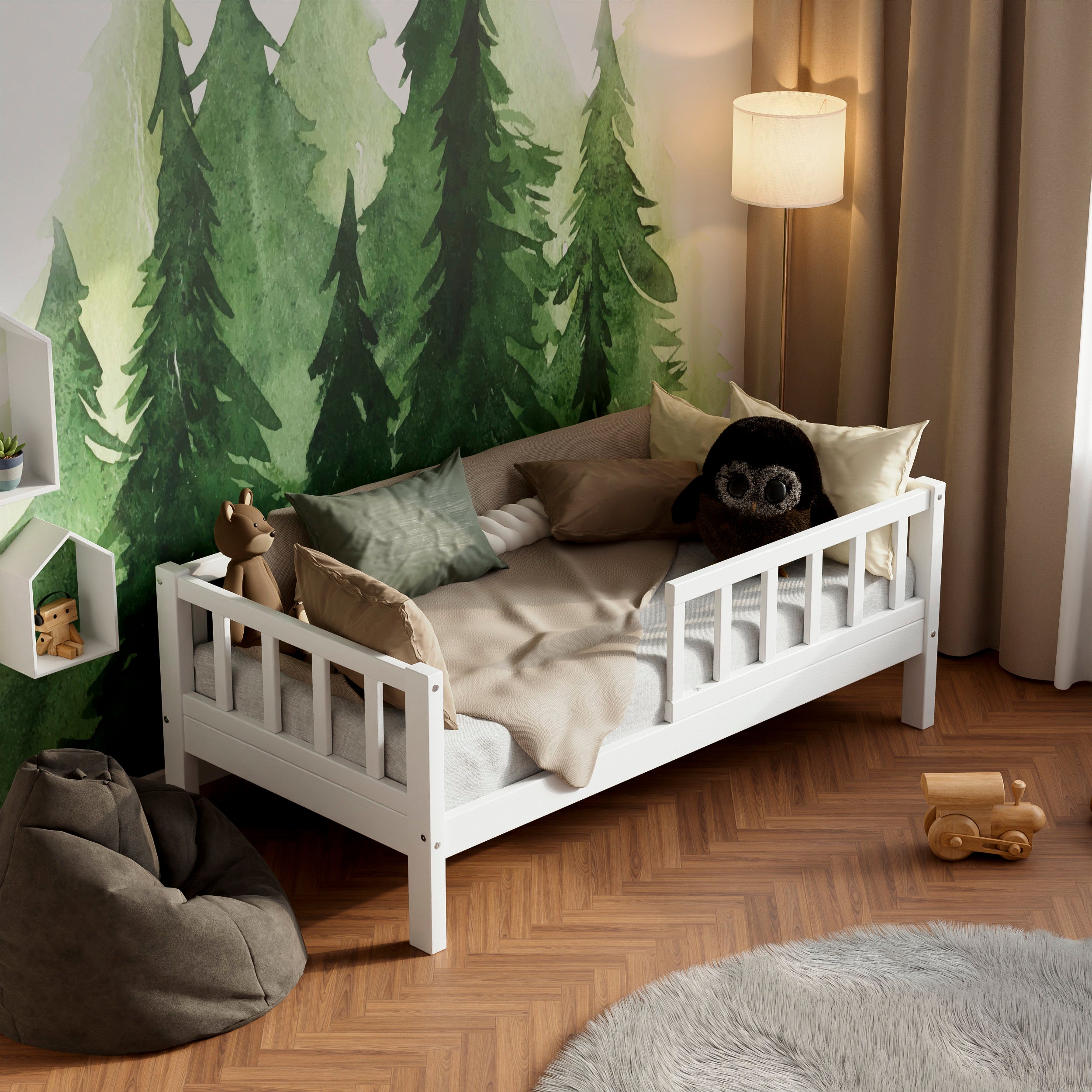 Lit d'enfant en bois blanc avec barrières dans une chambre d'enfant décorée de coussins et de jouets